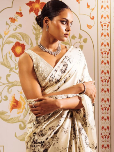 Woman in a floral saree with a decorative background