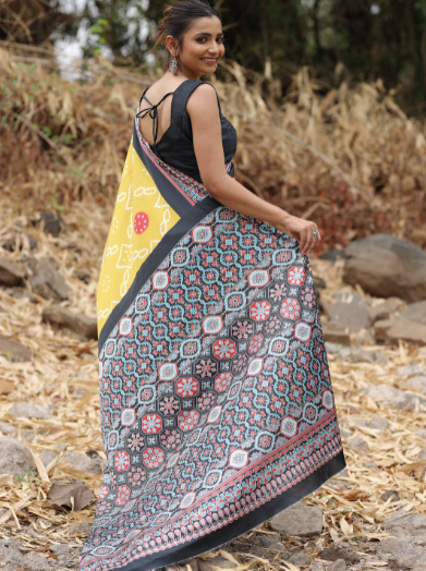 Woman wearing a colorful patterned saree outdoors on a natural background