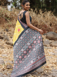 Woman wearing a colorful patterned saree outdoors on a natural background
