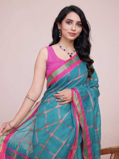 Woman wearing a green and pink saree with a beige background