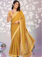 Woman wearing a yellow saree with a patterned background