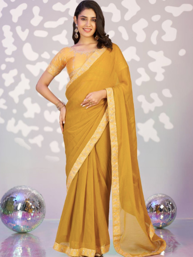 Woman wearing a yellow saree with a white patterned background