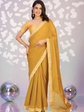 Woman wearing a yellow saree with a white patterned background