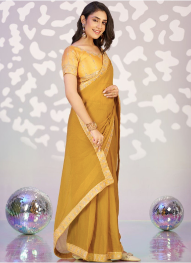 Woman in a yellow saree with a decorative background