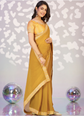 Woman in a yellow saree with a decorative background