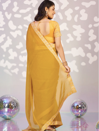 Woman wearing a yellow saree with a patterned background