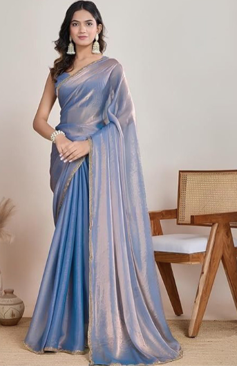 Woman wearing a blue saree with a plain background