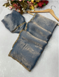Blue denim pouches with gold trim on a light gray surface with flowers in the background