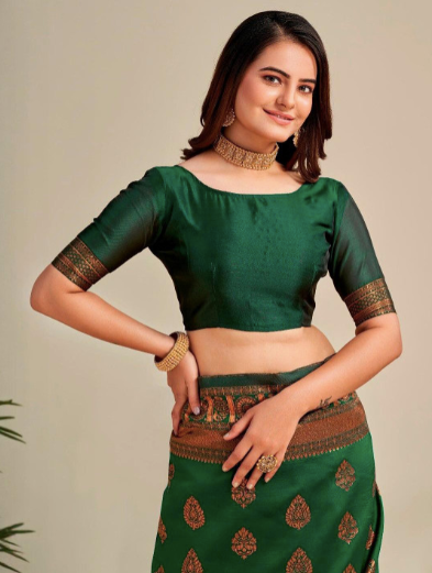 Woman wearing a green traditional outfit with gold patterns on a plain background