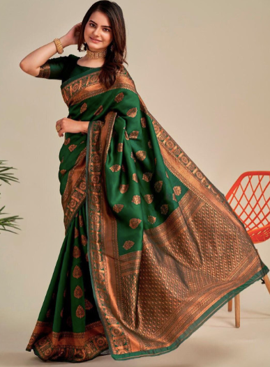 Woman wearing a green and brown saree with a neutral background