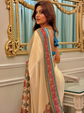 Woman in a traditional outfit with a decorative shawl in front of a mirror.