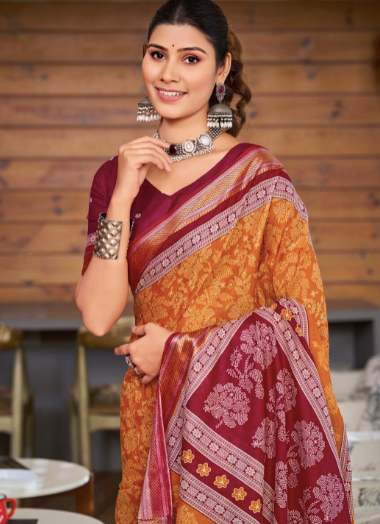 Woman wearing a traditional maroon and yellow saree with a blurred background