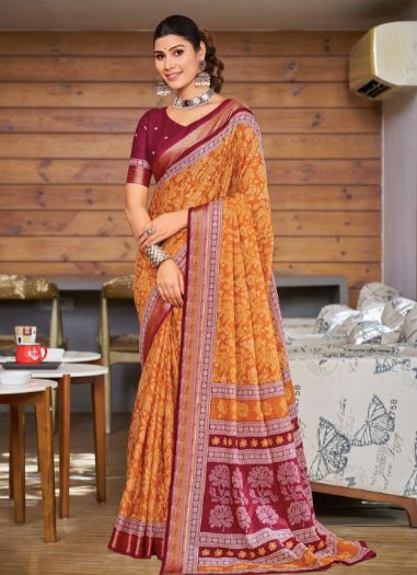 Woman wearing a traditional orange and red saree in an indoor setting