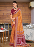 Woman wearing a traditional orange and red saree in an indoor setting