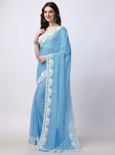 Woman wearing a light blue saree with white embroidery on a white background