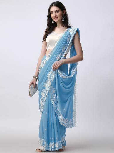 Woman wearing a blue saree with white lace on a white background
