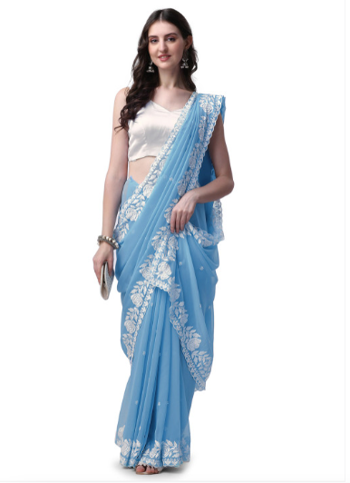 Woman wearing a light blue saree with white embroidery on a white background