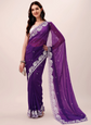 Woman wearing a purple saree with white embroidery on a beige background