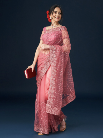 Woman in a pink saree with a dark background