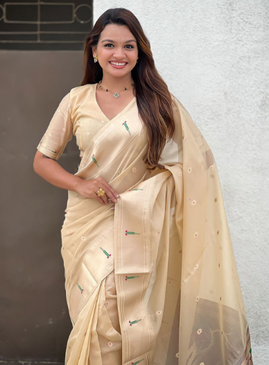 Woman wearing a beige saree with a white background