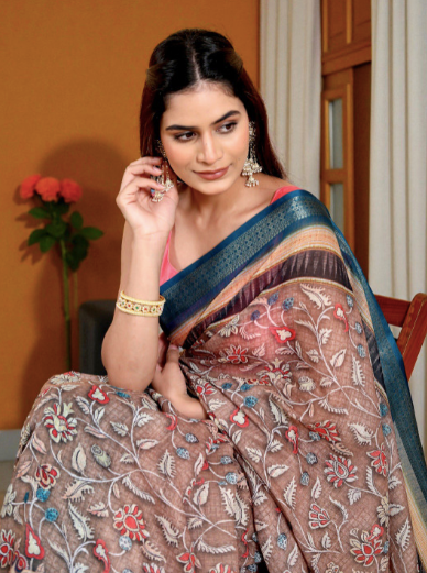 Woman wearing a traditional saree with floral patterns indoors.