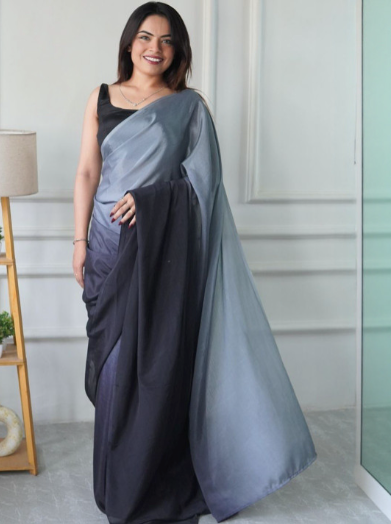 Woman wearing a gray and black saree in an indoor setting