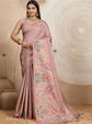 Woman wearing a pink saree with floral patterns against a beige background