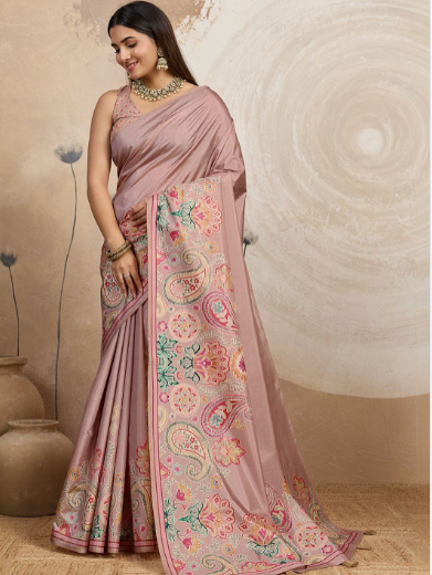 Woman wearing a pink saree with floral patterns against a neutral background