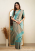 Woman wearing a blue and gray saree standing in front of a mirror.