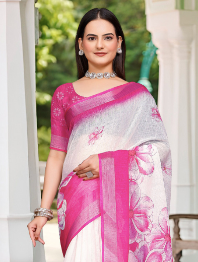 Woman wearing a white and pink saree with floral patterns outdoors.