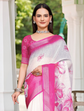 Woman wearing a white and pink saree with floral patterns outdoors.