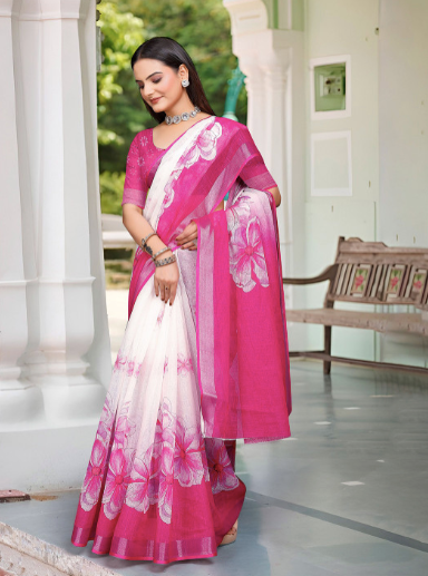 Woman wearing a pink and white saree with floral patterns indoors.