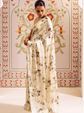 Woman in a floral dress standing in front of a decorated wall with floral patterns.