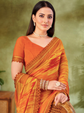 Woman wearing an orange saree with a green background