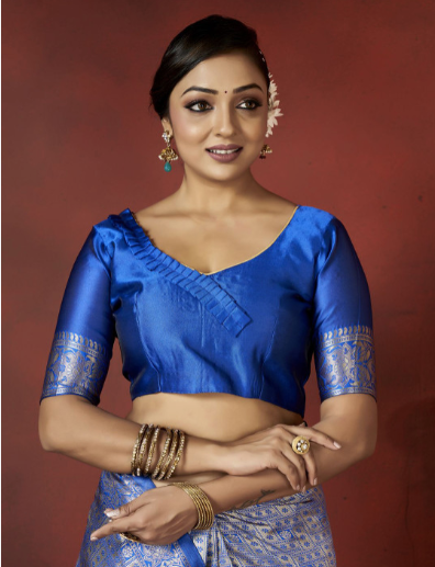 Woman wearing a blue traditional outfit with intricate designs on a red background