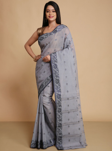 Woman wearing a gray saree with a beige background