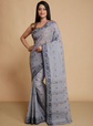 Woman wearing a gray saree with a beige background