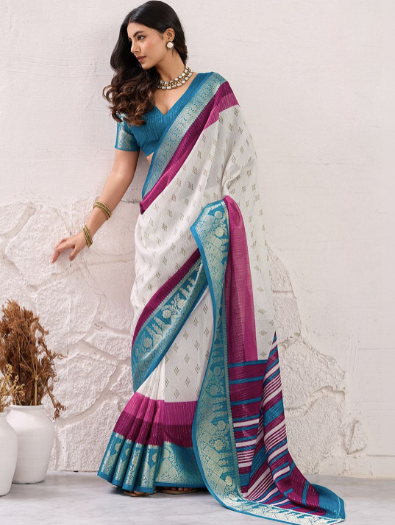 Woman wearing a colorful saree with a white textured wall background